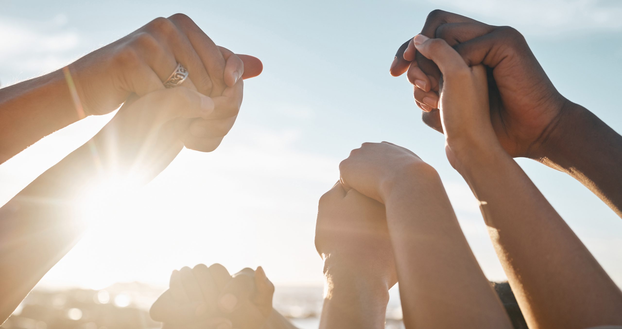 Friends, bonding and holding hands on beach social gathering, community trust support or summer holiday success. Men, women and diversity people in solidarity, team building or travel mission goals