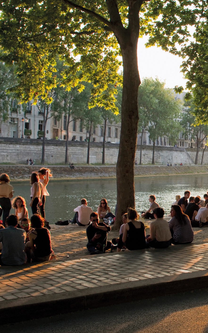 France, Paris, picnickers on the bank of the Seine, at the end of the day.
