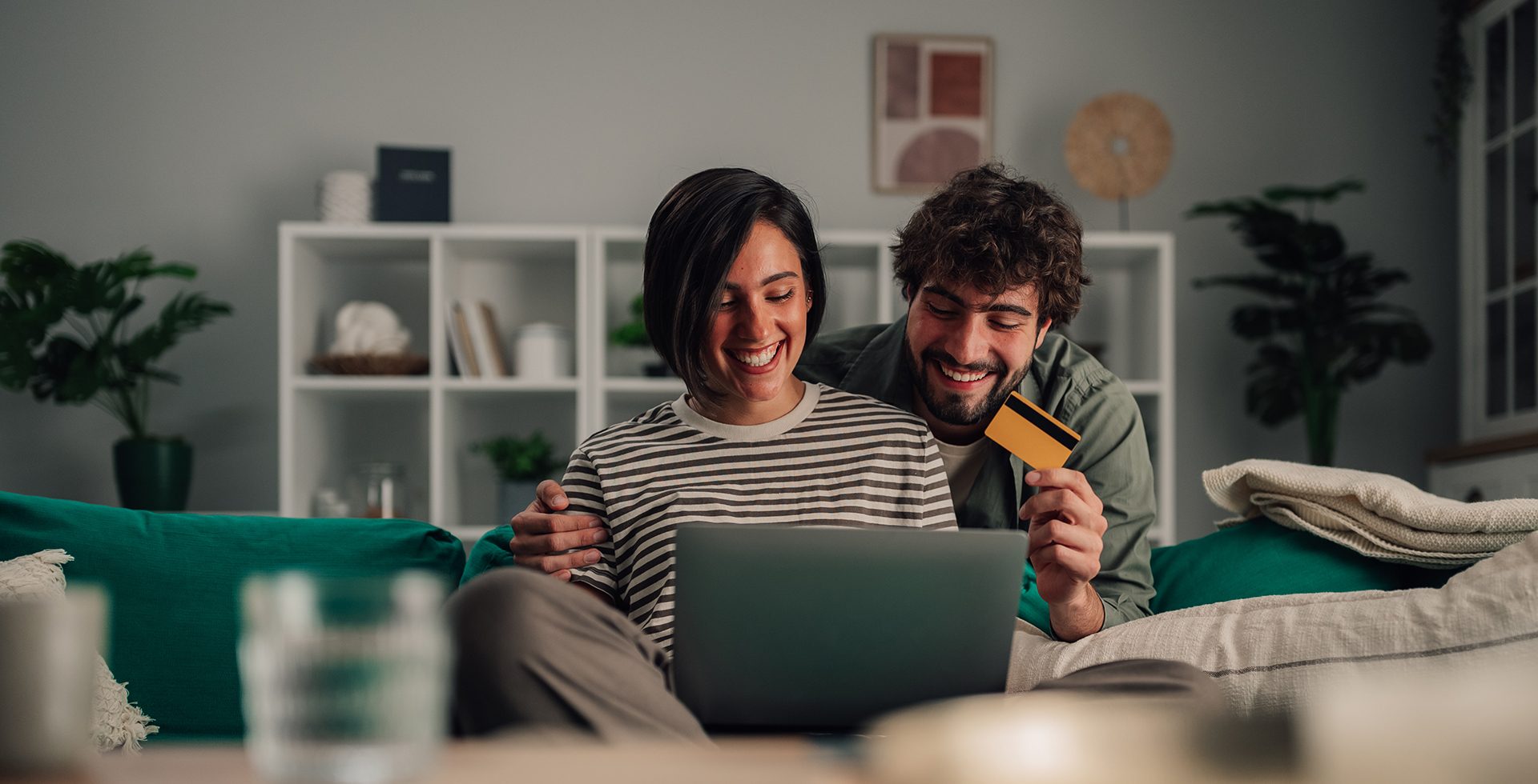 Happy couple enjoying online shopping with credit card and lapto