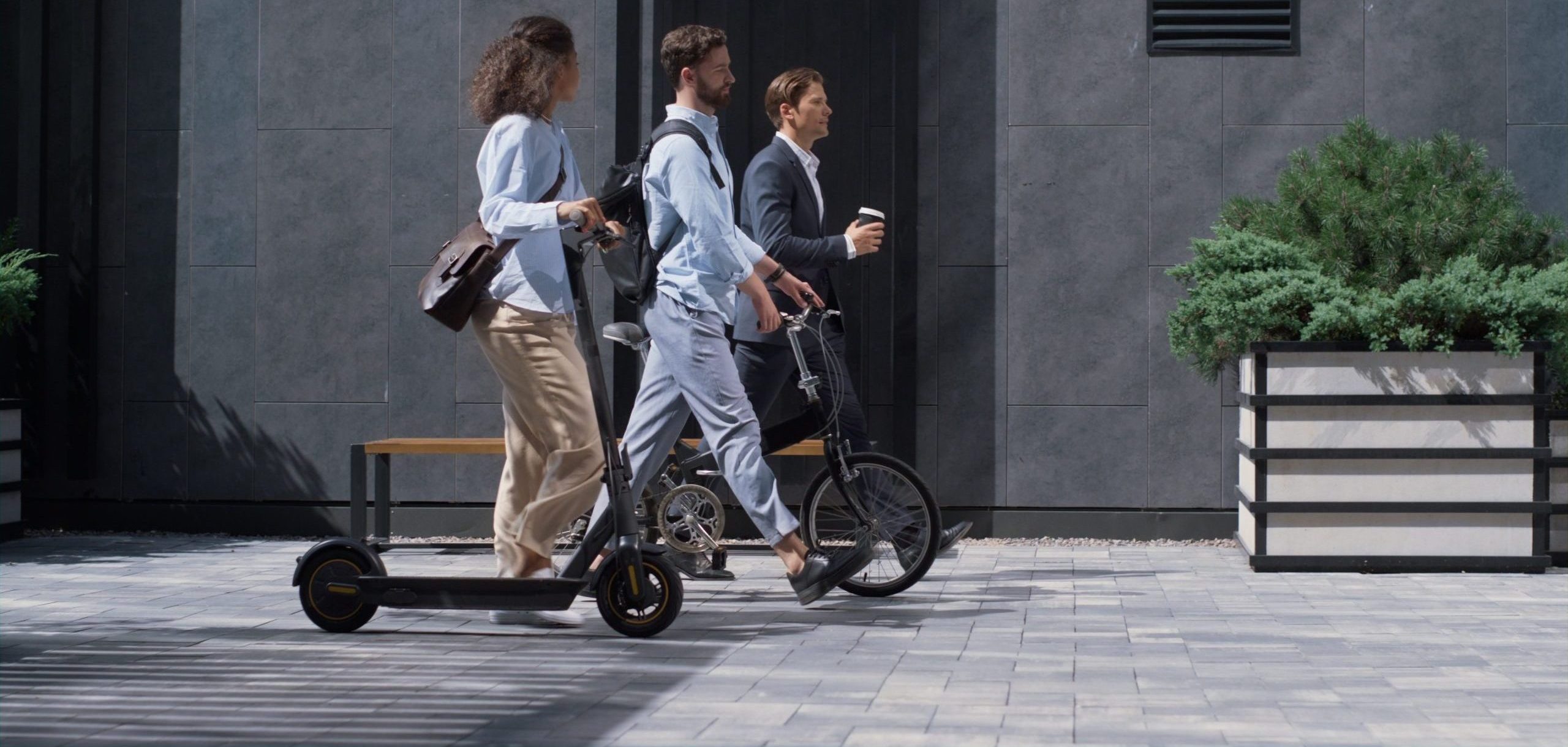 Two colleagues going downtown street talking. Shared eco-friendly transportation